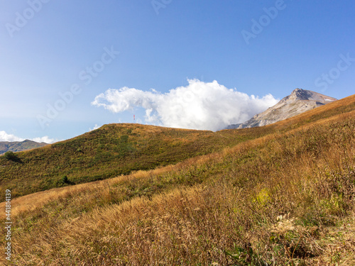 Fototapeta Naklejka Na Ścianę i Meble -  Panoramic views of the mountains from hiking trails in the mountainous area on a warm, sunny autumn day, walking and communicating with nature.