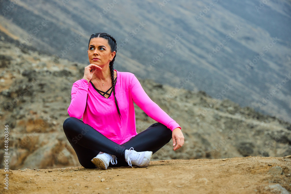 mature woman meditating on the mountain in sportswear