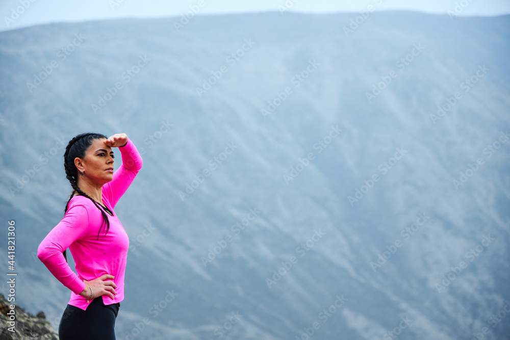 mature woman meditating on the mountain in sportswear