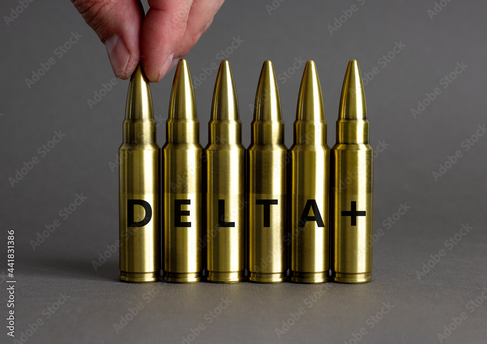 Covid-19 new delta plus variant symbol. Ammunitions imitation with words delta plus. Doctor hand. Beautiful grey background, copy space. Medical and COVID-19 new delta plus variant concept. Covid-19 new delta plus variant symbol. Ammunitions imitation with words delta plus. Doctor hand. Beautiful grey background, copy space. Medical and COVID-19 new delta plus variant concept.