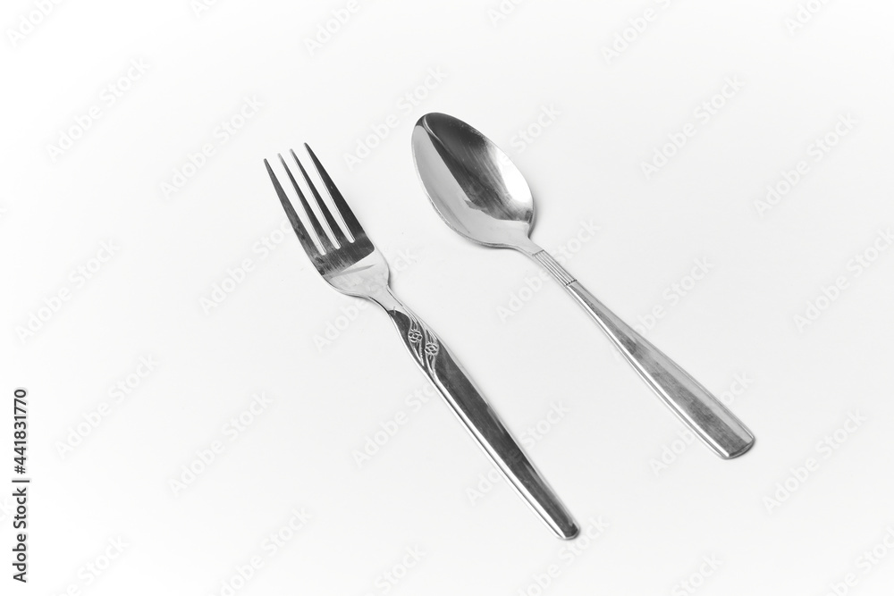 Silvery fork and spoon isolated on white, stainless silverware, tableware and kitchenware Silvery fork and spoon isolated on white, stainless silverware, tableware and kitchenware