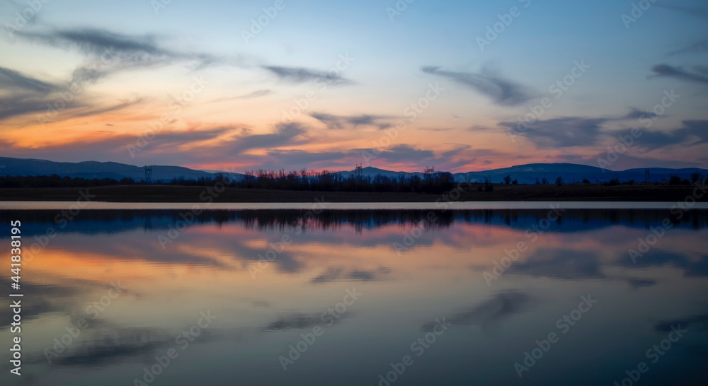 The beautiful colors of the sunset reflected in the waters of the dam. Kyustendil, Bulgaraia The beautiful colors of the sunset reflected in the waters of the dam. Kyustendil, Bulgaraia