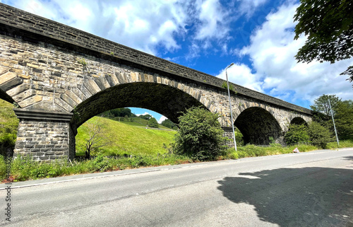 Victorian Stone viaduct, with fields and trees visible between the arches, next to the, Halifax Road, Todmorden, UK