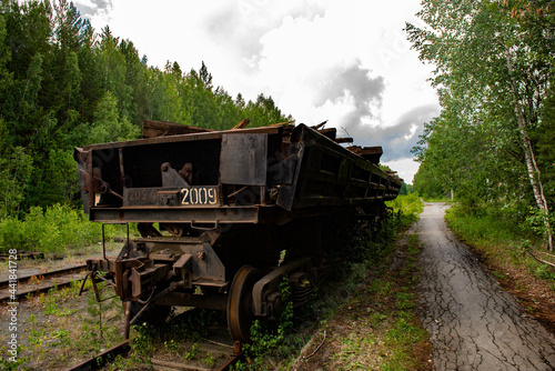 an abandoned Russian car on the rails in the forest