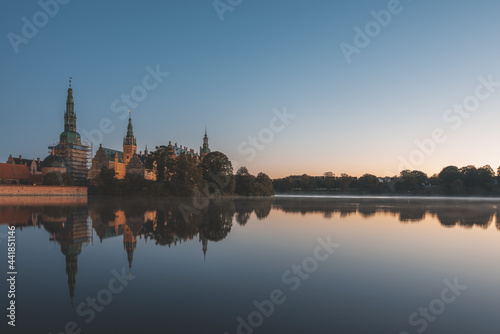 the calm lake of Frederiksborg with reflections of the castle at sunrise © Stig Alenas