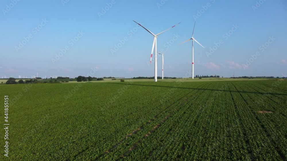 Energy transition: Renewable energies from wind power. Wind turbines in an agricultural field on a summer afternoon.