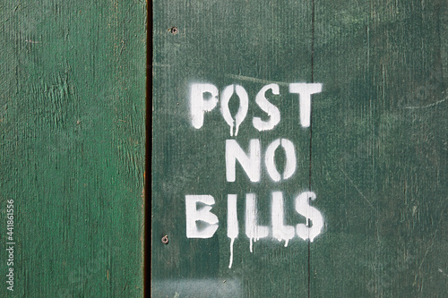 Post no bills on green wooden fence photo