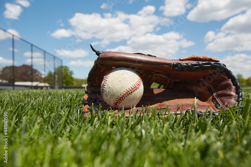 Baseball glove and ball on grass photo