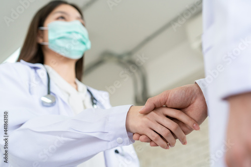 Two senior specialist doctor making a handshake together.