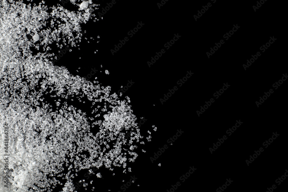 the pile white sugar on a black background