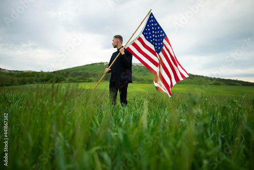 Young man with American flag in wheat field photo