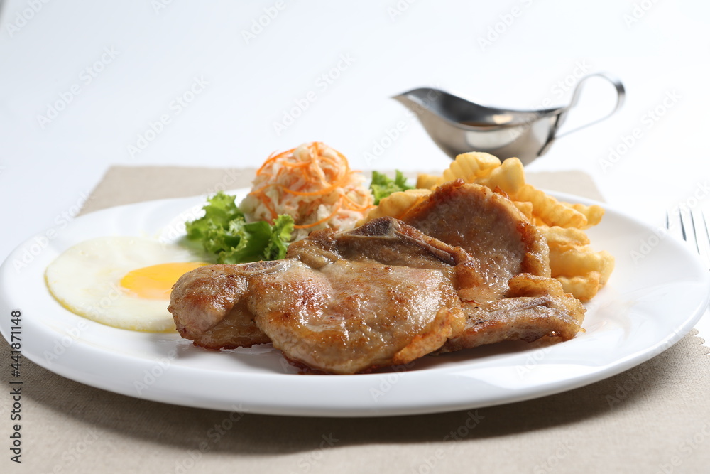 grilled golden bbq meat chicken cop pork cutlet beef steak with fried egg, French fries, coleslaw salad and black pepper sauce in pot western cuisine menu grilled golden bbq meat chicken cop pork cutlet beef steak with fried egg, French fries, coleslaw salad and black pepper sauce in pot western cuisine menu