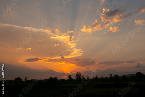 Beautiful sunset on the background of nature. Natural landscape. Blue sky and orange clouds of the evening summer landscape.