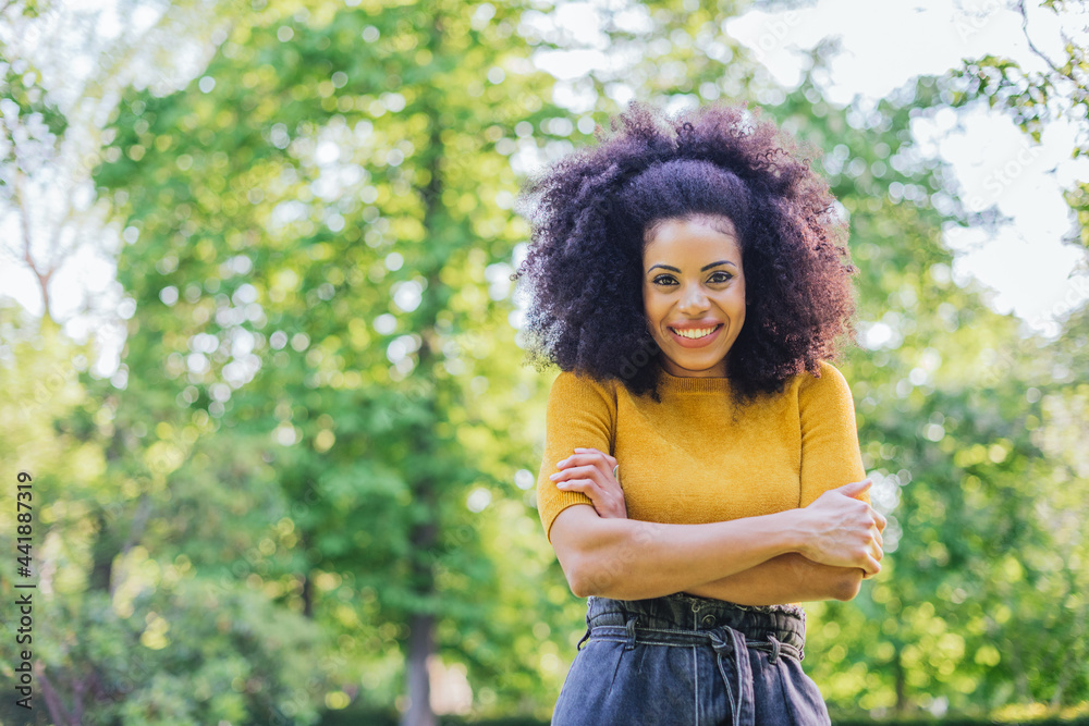 Portrait of nice afro girl smiling in a garden. Mid shot.