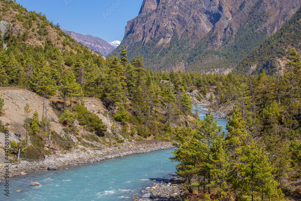 Beautiful landscape with high Himalayan mountains, curving river, green forest and blue sky in autumn in Nepal Beautiful landscape with high Himalayan mountains, curving river, green forest and blue sky in autumn in Nepal