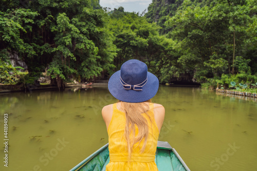 Woman tourist in boat on the lake Tam Coc, Ninh Binh, Viet nam. It's is UNESCO World Heritage Site, renowned for its boat cave tours. It's Halong Bay on land of Vietnam. Vietnam reopens borders after