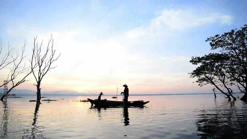 Asian fisherman on wooden boat casting a net for catching freshwater fish in nature river in the early morning before sunrise
Asian fisherman on wooden boat casting a net for catching freshwater fish in nature river in the early morning before sunrise
