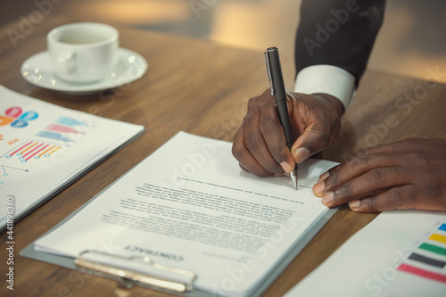 Close up business African American businessman signed on the contract documents. Business agreement contract concept.