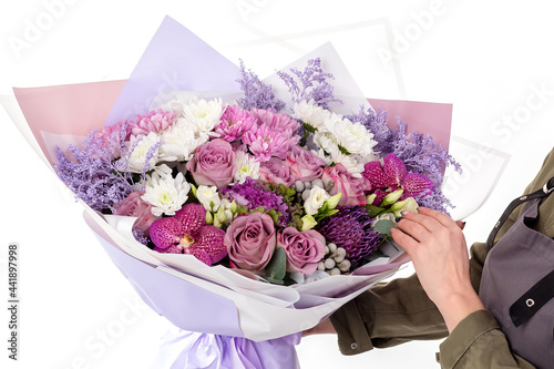 Fototapeta Naklejka Na Ścianę i Meble -  Woman florist in uniform hold a big flowers bouquet of purple roses.