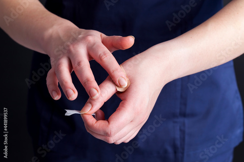 a woman in medical clothing puts a band on her hand