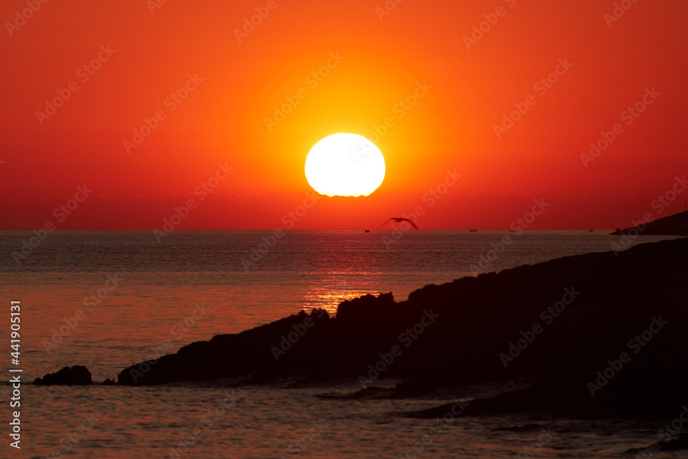 Silhouette of a cliff coast and ocean water in sunset sunrise ti