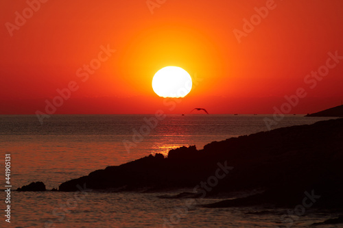 Silhouette of a cliff coast and ocean water in sunset sunrise ti