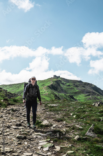 young hiker man in mountains. summer trekking path