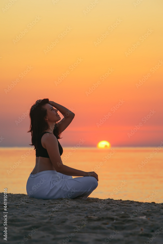 young woman sitting at sea beach looking on sunrise young woman sitting at sea beach looking on sunrise
