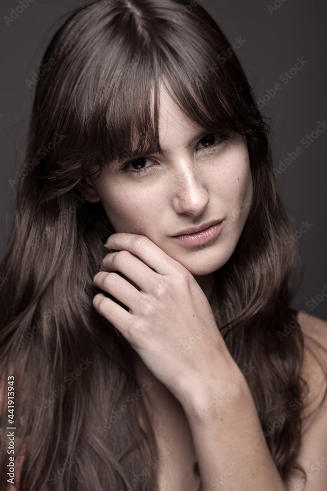 Freckled woman touching face with manicured hand Freckled woman touching face with manicured hand