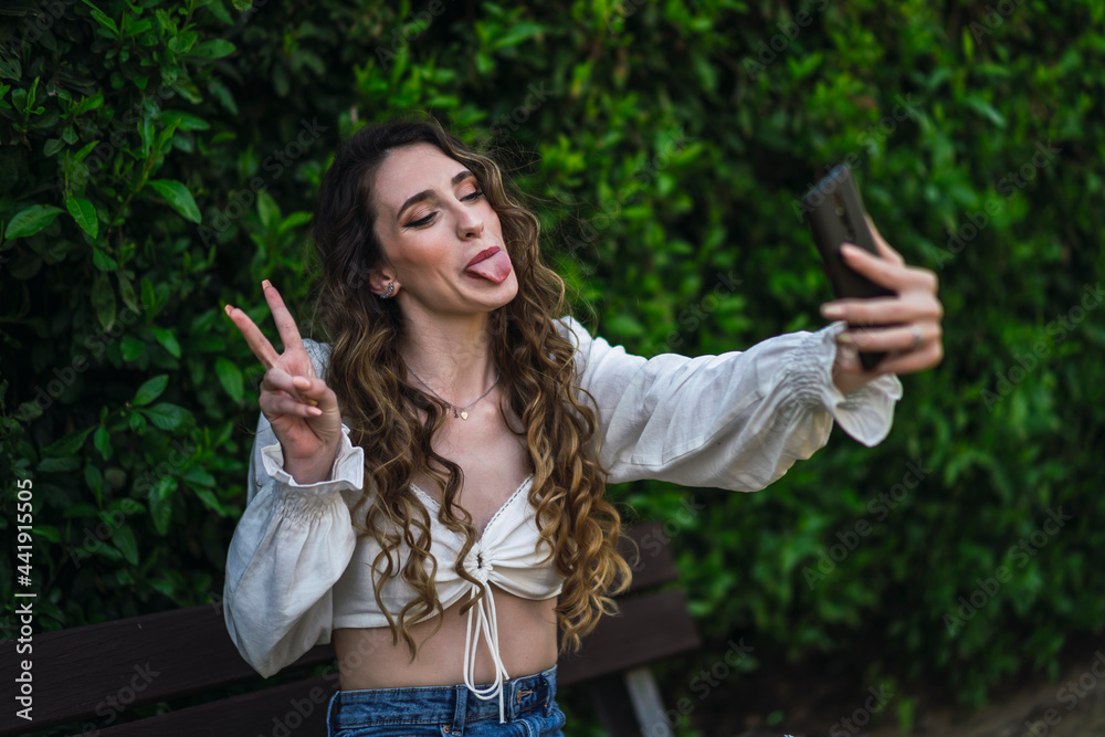 Cheerful woman with tongue out taking selfie Cheerful woman with tongue out taking selfie