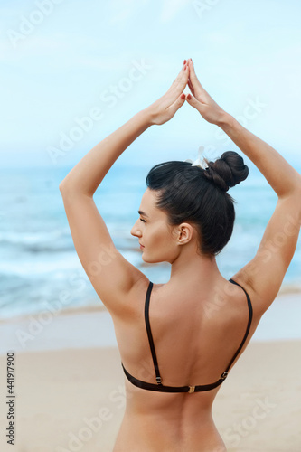 Beautiful woman practices yoga and meditates on th ebeach. Girl doing yoga. Active Lifestyle. Healthy and yoga concept.