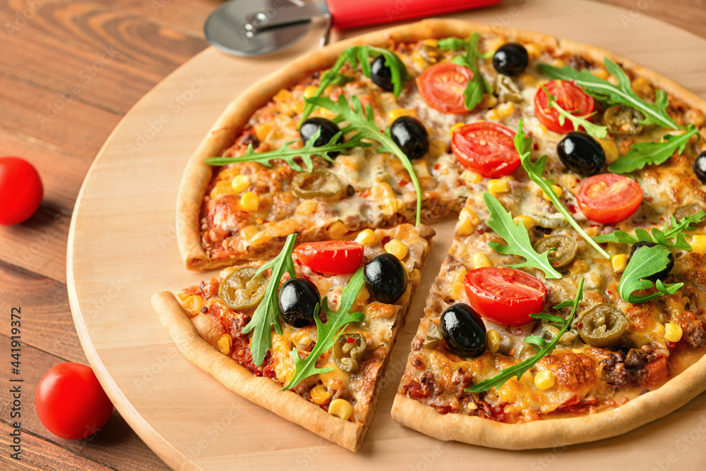 Board with tasty pizza on wooden background, closeup