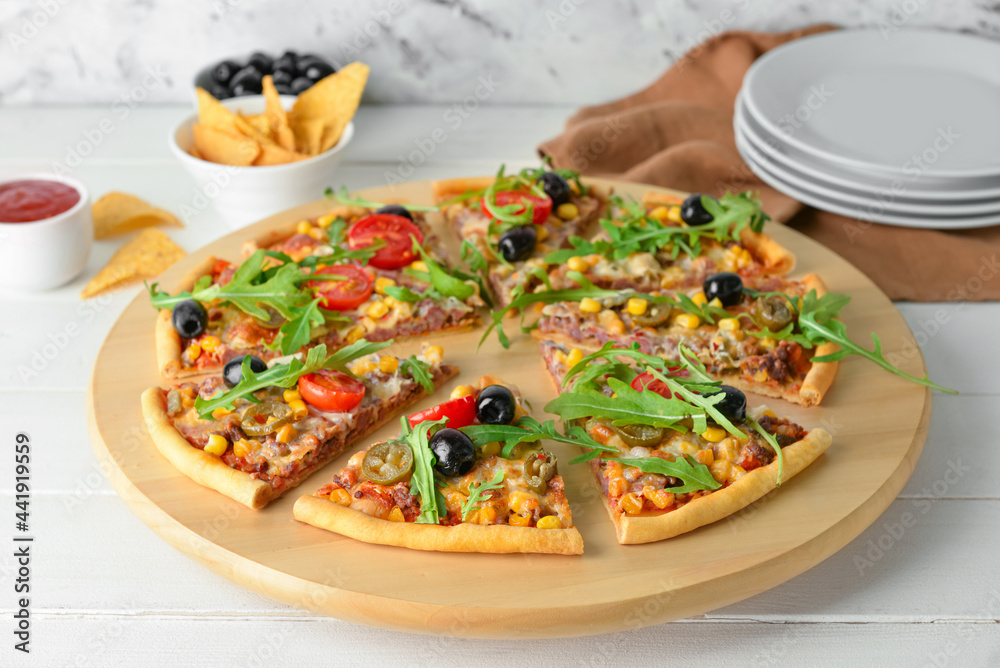 Board with slices of tasty pizza, sauce and nachos on light wooden background Board with slices of tasty pizza, sauce and nachos on light wooden background