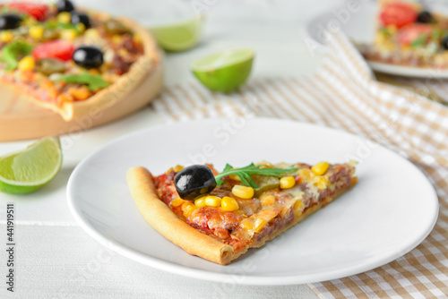 Plate with slice of tasty pizza on light wooden background, closeup