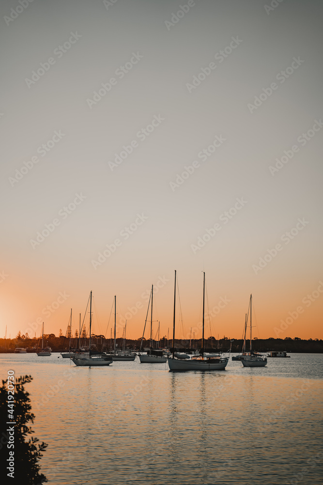 Boats and yachts sitting on the river at sunset near the Yamba Marina on the Clarence River.