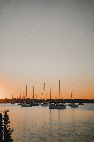 Boats and yachts sitting on the river at sunset near the Yamba Marina on the Clarence River. © Nick