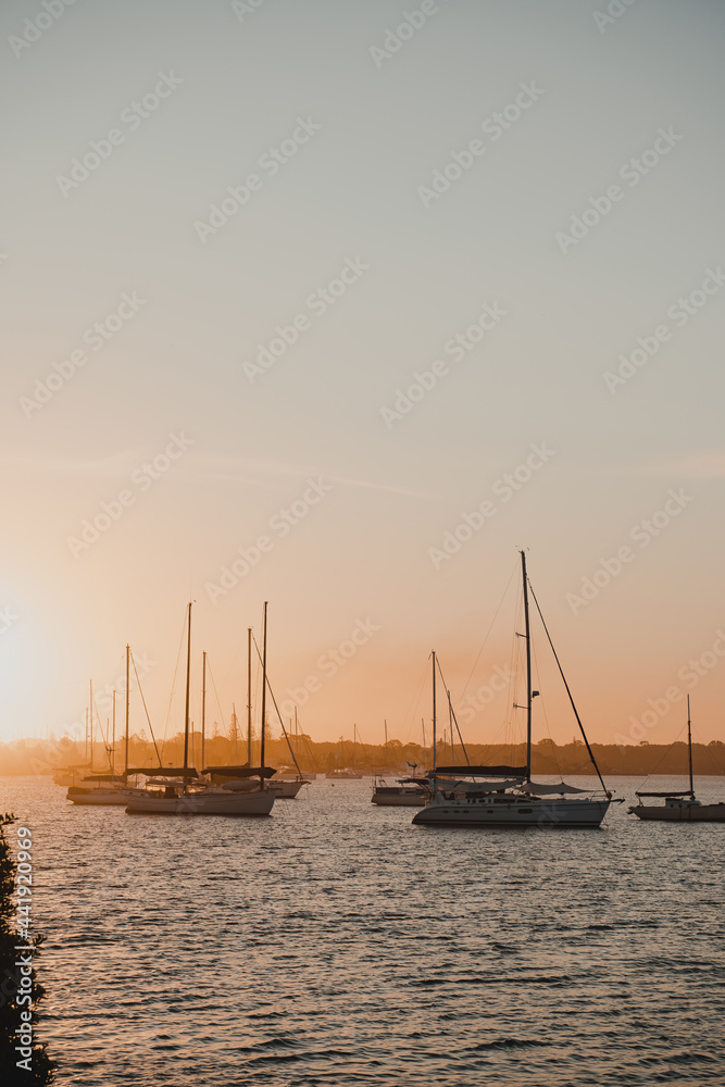 Boats and yachts sitting on the river at sunset near the Yamba Marina on the Clarence River.