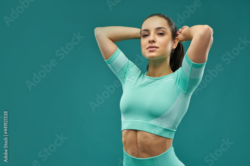 Attractive young woman in sportswear fixing her hair