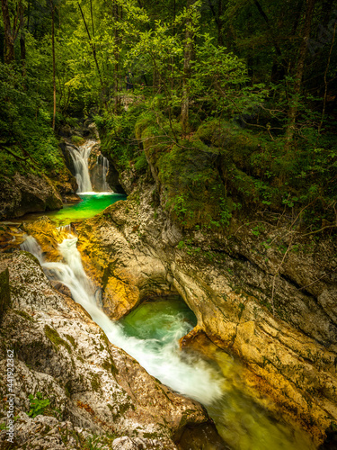Green pool and waterfall of river Lepenca in Sunik water grove, Lepena valley, Bovec, Slovenia, water background, turquoise, mountain river, stream, Soca valley, Triglav national park, Europe. photo