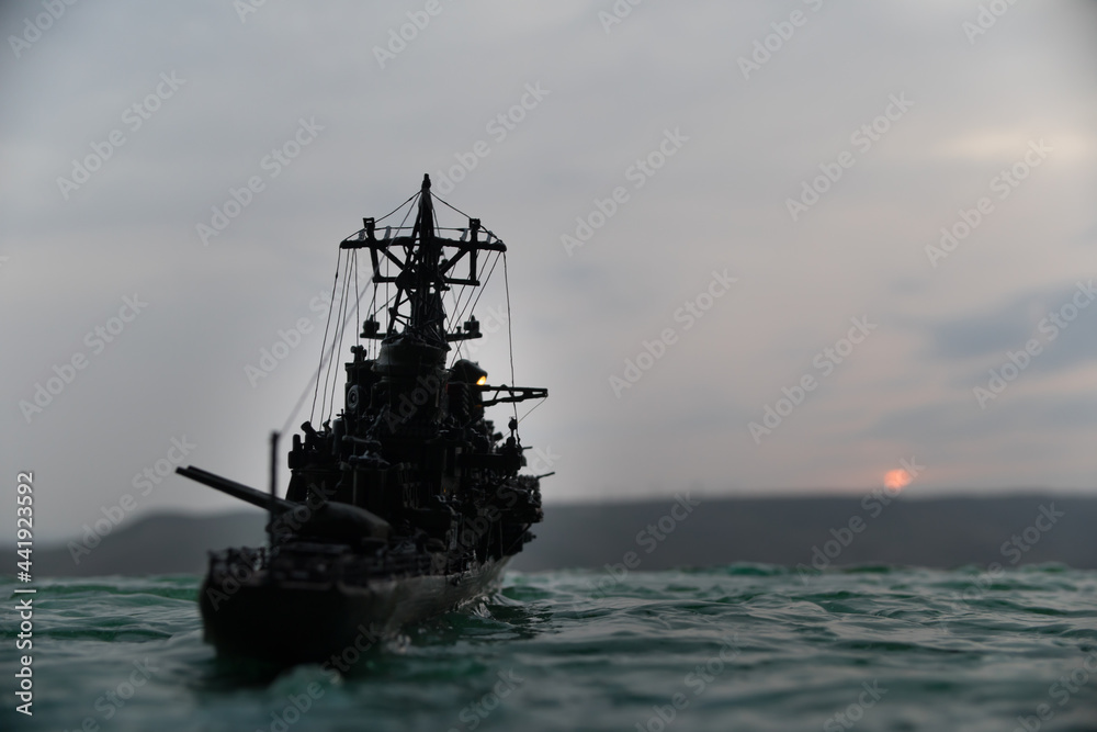 Silhouettes of a crowd standing at blurred military war ship on foggy background. Selective focus.