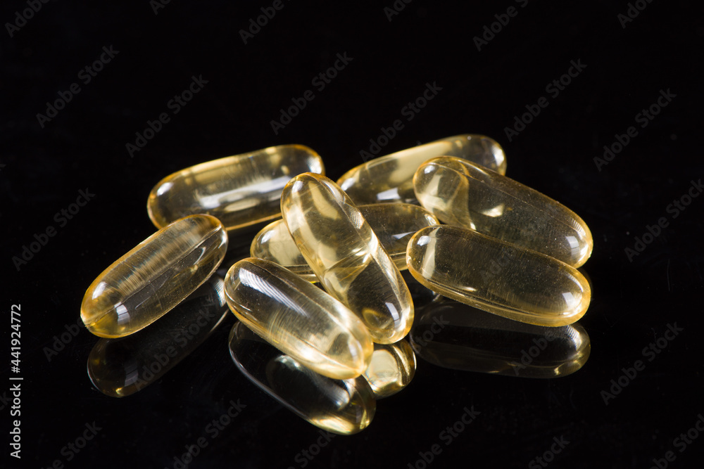 gold fish oil capsules on white background gold fish oil capsules on white background