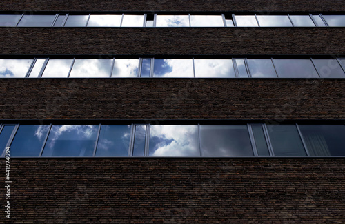 Office building made out of bricks - mirroring cloudscape in the windows of the offices