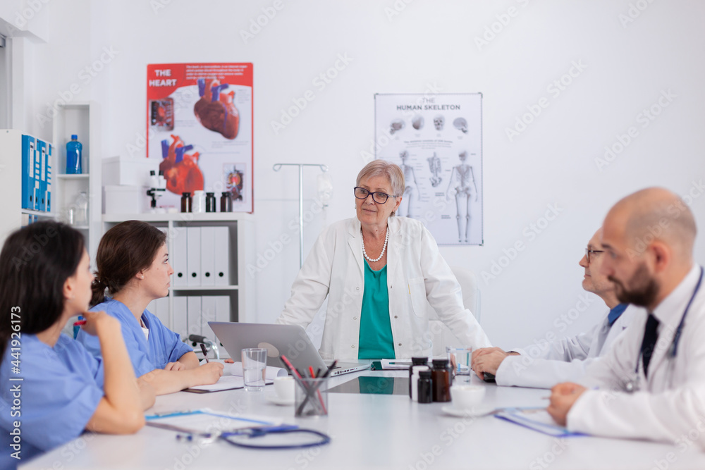 Physicians teamwork in white coats working at healthcare medical expertise in conference meeting room presenting sickness diagnosis. Radiologist therapist doctor discussing health examination