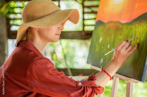 Canvas Print Young female artist working on her art canvas painting outdoors in her garden