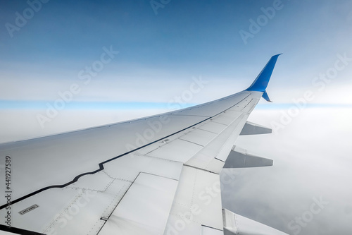 View from the window of a passenger plane above the clouds. International cargo transportation, air travel, transport, air travel, vacations. Copy space.