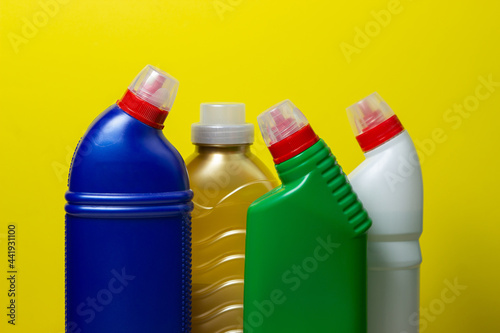 Household chemicals on a yellow background. Household cleaning products.