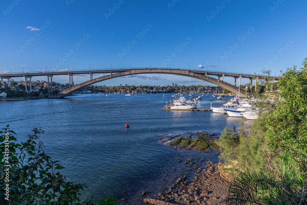 Panorama view of Gladesville Bridge Parramatta river on Sydney harbour foreshore NSW Australia. Boats Yachts and ferry with luxury houses on the bay Panorama view of Gladesville Bridge Parramatta river on Sydney harbour foreshore NSW Australia. Boats Yachts and ferry with luxury houses on the bay