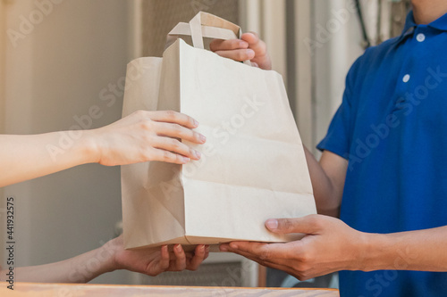 Canvastavla Happy asian young woman protect  pandemic of covid-19 and received paper bag from delivery man, messenger in blue uniform while lockdown, quarantine at front door home, apartment
