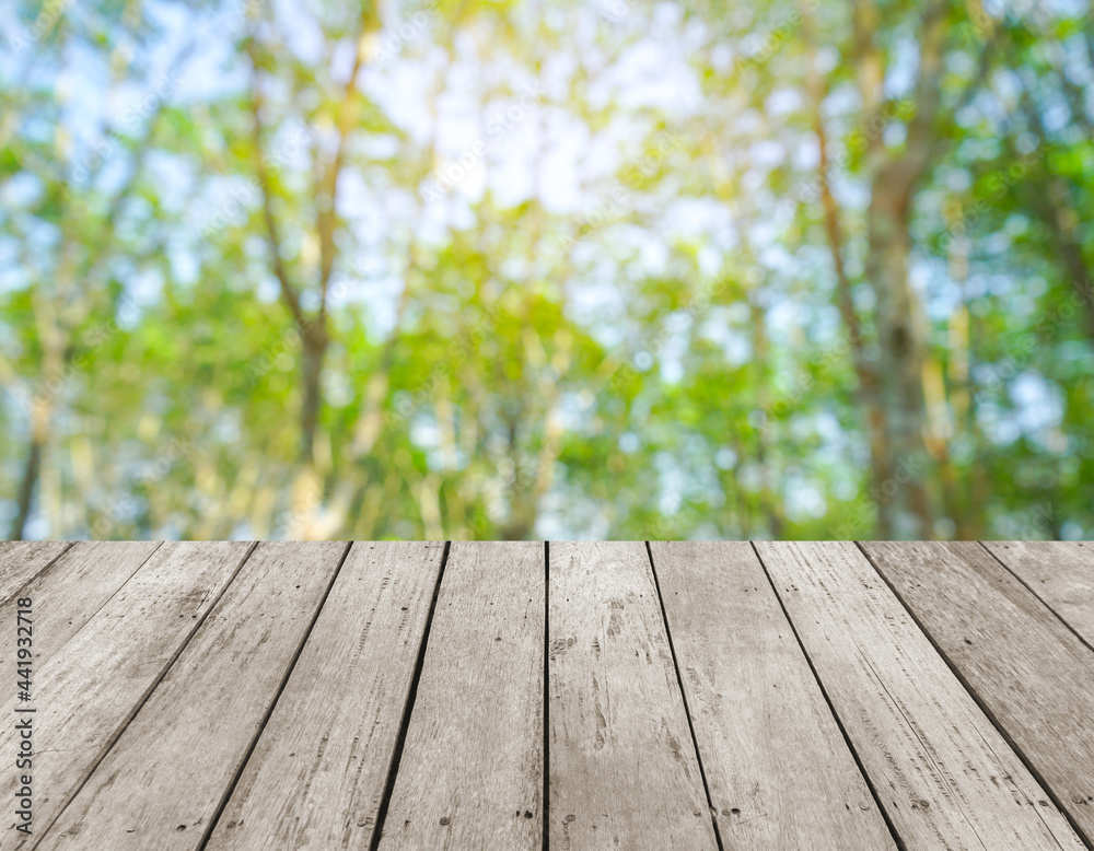 Old wood plank with abstract tree bokeh blurred background for product display Old wood plank with abstract tree bokeh blurred background for product display