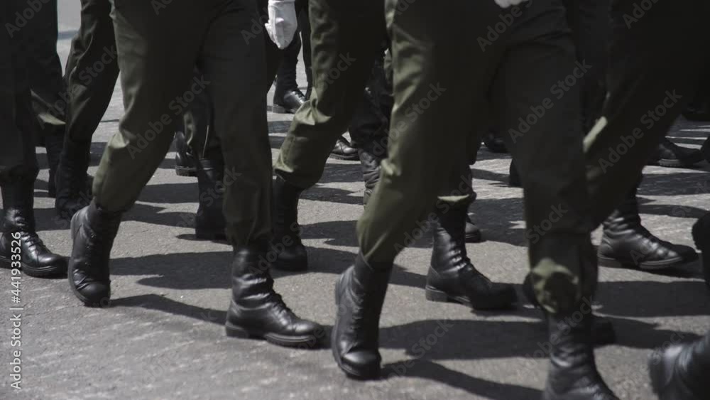 Close-up of soldiers ' feet in army boots marching through the streets of the city during a military parade. Close-up of soldiers ' feet in army boots marching through the streets of the city during a military parade.